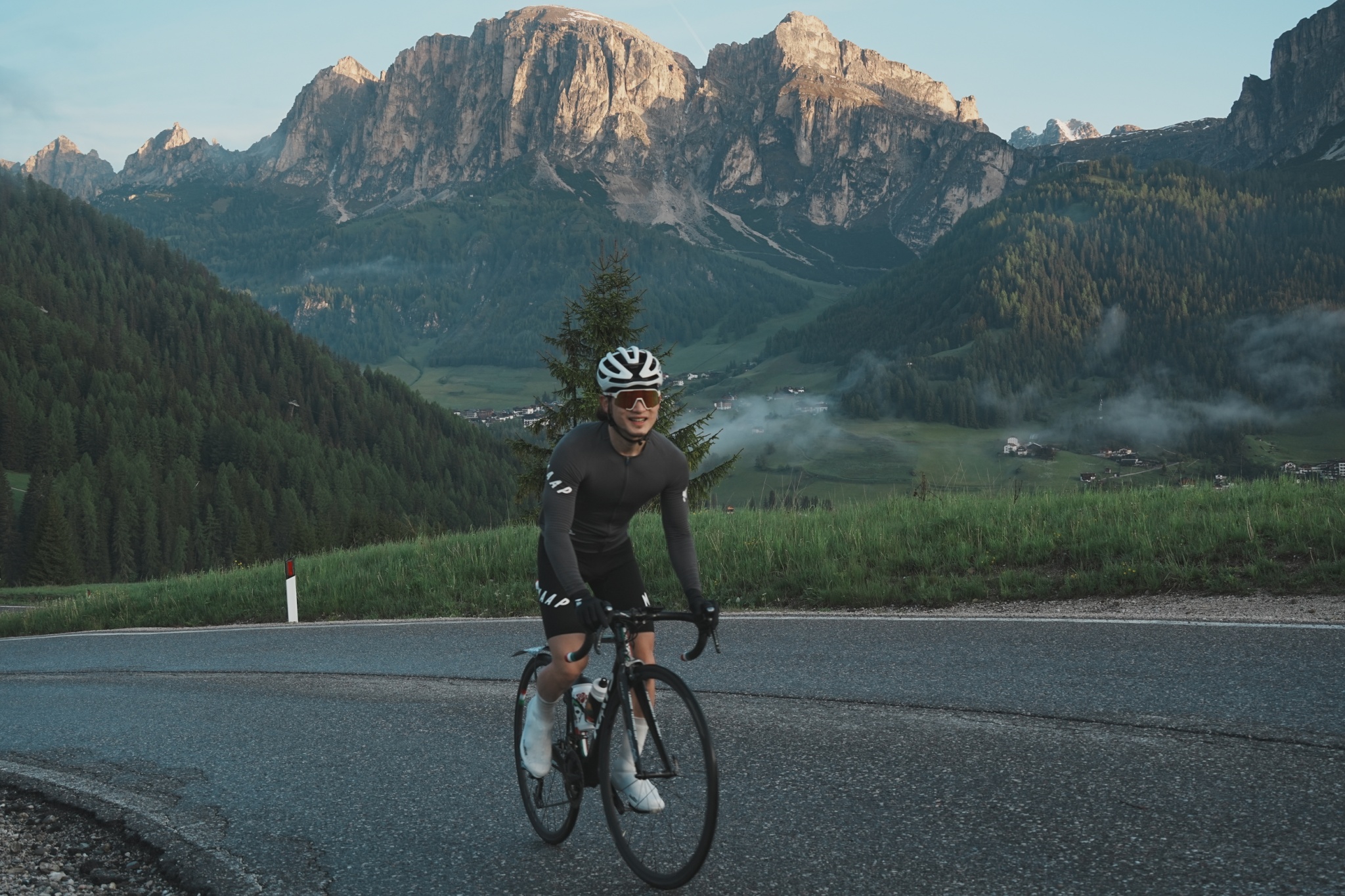 Cyclist climbing on a road above an Alpine valley