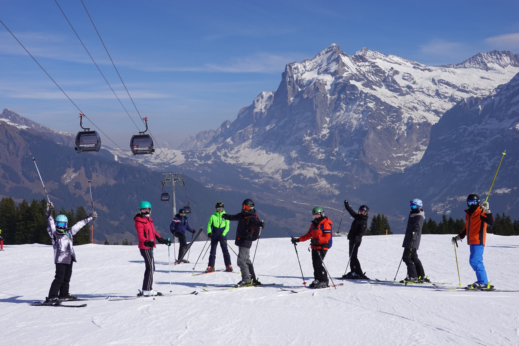 Skiers and gondolas beneath the Jungfrau mountains