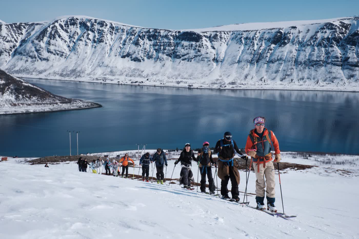 Ski tourers climbing above the Lyngen fjords