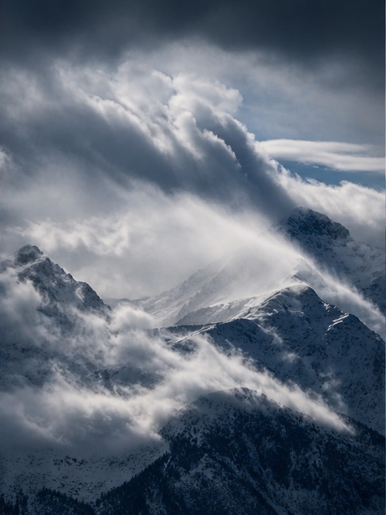 Winter storm clouds moving across Alpine peaks